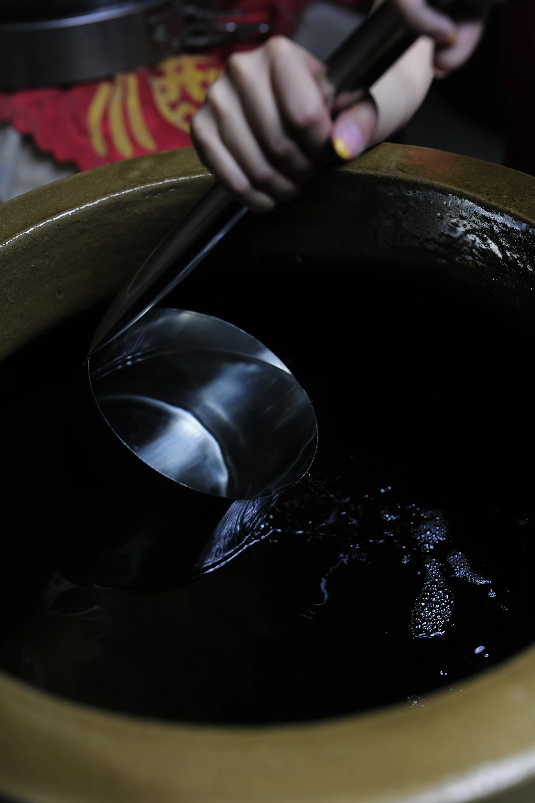 The ceremonial pouring begins with a traditional metal ladle